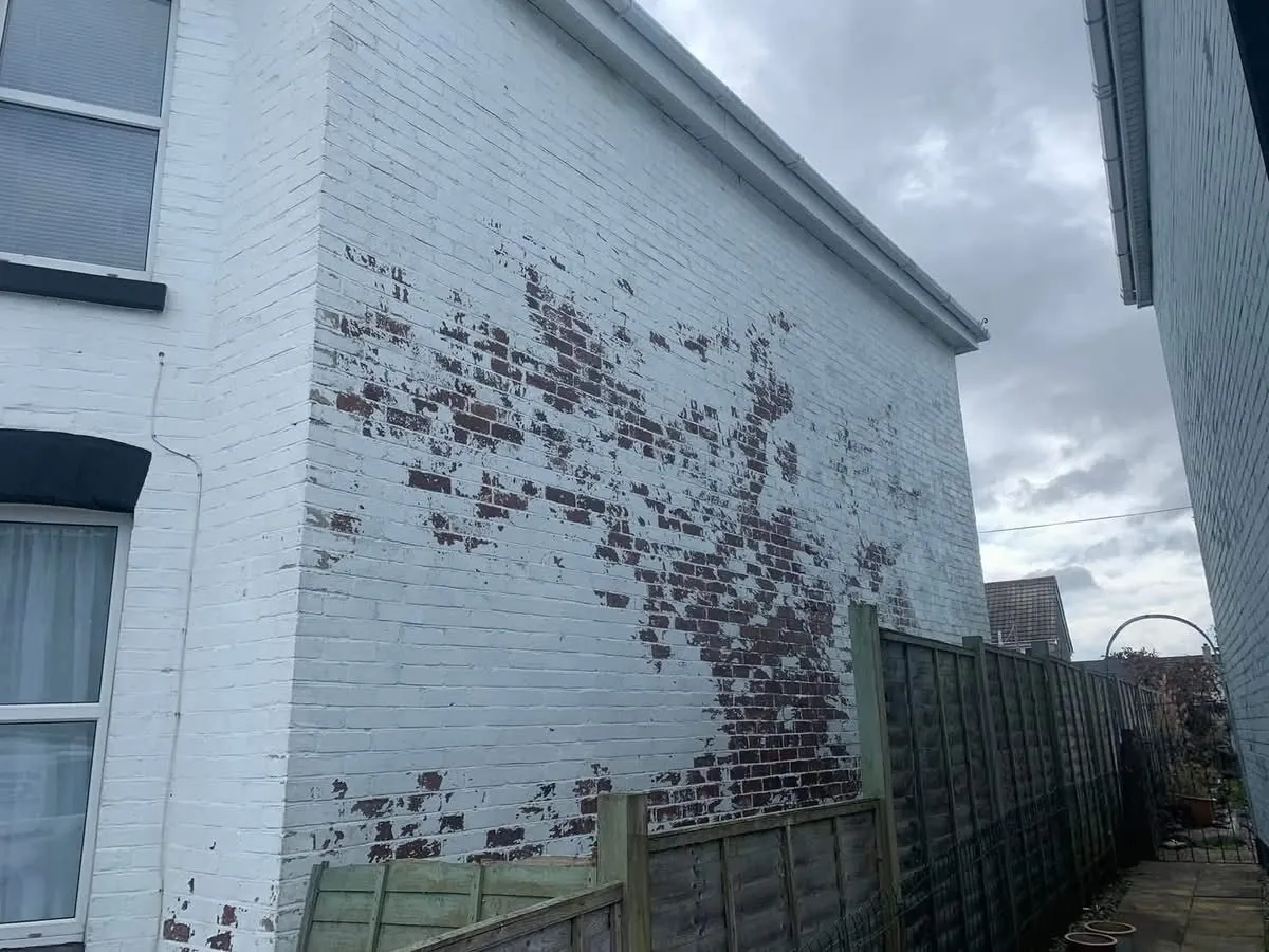 Peeling paint on a brick wall before redecoration in Saltash
